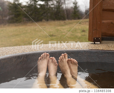 two pairs of female legs in a hot tub outdoors two pairs of female legs in a hot tub outdoors 116485108