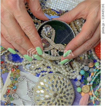 women's hands with painted nails on a background of jewelry 116485191