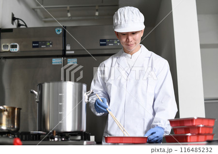 弁当箱に料理を詰める男性の調理スタッフ 弁当箱に料理を詰める男性の調理スタッフ 116485232