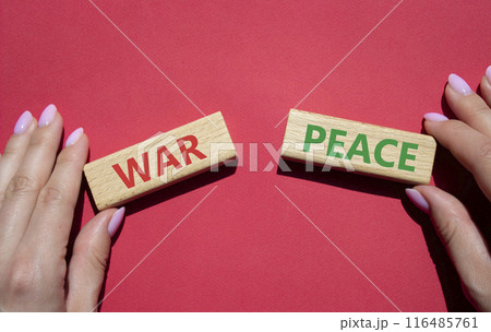 War or Peace symbol. Concept word War or Peace on wooden blocks. Businessman hand. Beautiful red background. Business and War or Peace concept. Copy space 116485761
