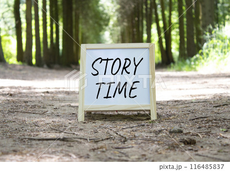 Story Time symbol. Concept word Story Time on white chalk background. Beautiful forest background. Business and Story Time concept. Copy space Story Time symbol. Concept word Story Time on white chalk background. Beautiful forest background. Business and Story Time concept. Copy space 116485837