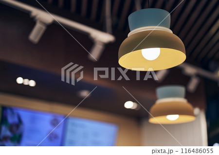 Vintage lamps hang from the ceiling in the cafe. A luxurious retro light bulb, vintage-style glowing bulbs hanging from the ceiling. With space to copy. High quality photo 116486055