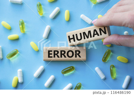 Human Error symbol. Concept word Human Error on wooden blocks. Beautiful blue background with pills. Doctor Hand. Medicine and Human Error concept. Copy space 116486190