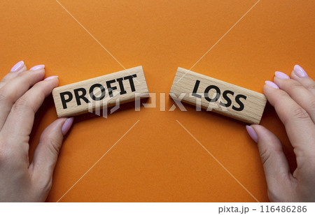 Profit or Loss symbol. Concept word Profit or Loss on wooden blocks. Businessman hand. Beautiful orange background. Business and Profit or Loss concept. Copy space Profit or Loss symbol. Concept word Profit or Loss on wooden blocks. Businessman hand. Beautiful orange background. Business and Profit or Loss concept. Copy space 116486286