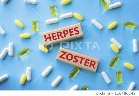 Herpes Zoster symbol. Concept word Herpes Zoster on wooden blocks. Beautiful blue background with pills. Medicine and Herpes Zoster concept. Copy space 116486348