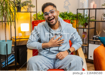 Indian man laughing out loud after hearing ridiculous anecdote, funny joke, feeling carefree amused Indian man laughing out loud after hearing ridiculous anecdote, funny joke, feeling carefree amused 116486580