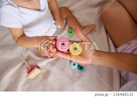 Mother and baby engaging in playful learning with colorful wooden toys Mother and baby engaging in playful learning with colorful wooden toys 116488132