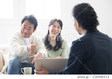 営業マンの説明を受ける笑顔の50代夫婦 投資や保険、不動産など 営業マンの説明を受ける笑顔の50代夫婦 投資や保険、不動産など 116490313