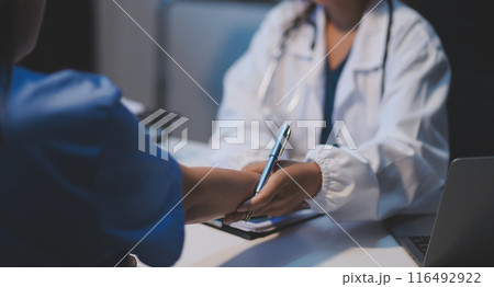 Doctor giving hope. Close up shot of young female physician leaning forward to smiling elderly lady patient holding her hand in palms. Woman caretaker in white coat supporting encouraging old person Doctor giving hope. Close up shot of young female physician leaning forward to smiling elderly lady patient holding her hand in palms. Woman caretaker in white coat supporting encouraging old person 116492922