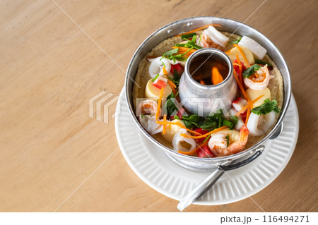 A delicious hot pot filled with steamed egg and an assortment of fresh seafood is beautifully displayed A delicious hot pot filled with steamed egg and an assortment of fresh seafood is beautifully displayed 116494271