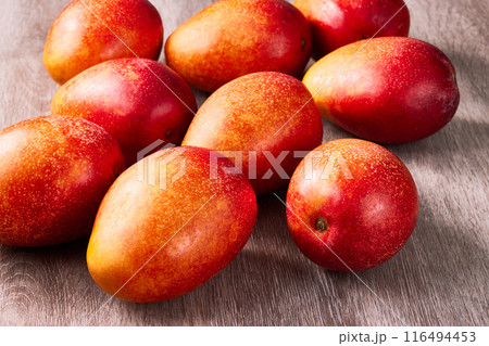 木のテーブルに沢山の完熟アップルマンゴー 116494453