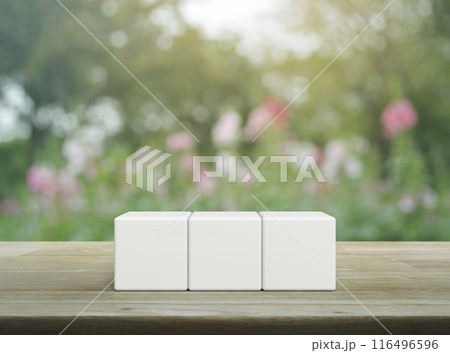 Three white block cubes on wooden table 116496596