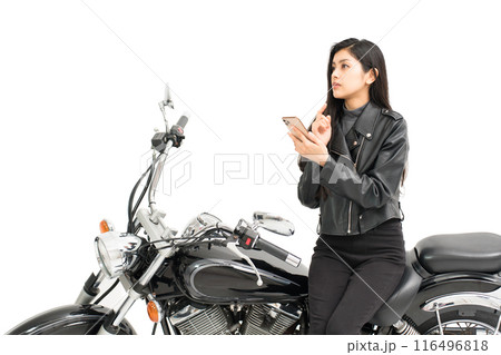 バイクに座ってスマホの地図を見て悩む若い女性 バイクに座ってスマホの地図を見て悩む若い女性 116496818