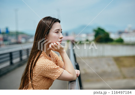 頬杖をついて景色を眺める若い女性 116497184