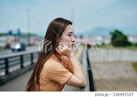 頬杖をついて景色を眺める若い女性 116497187