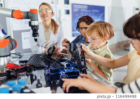 Children learning robotics in Elementary school. Young students building robot in after school robotics club. Field trip to real robotics laboratory. Children learning robotics in Elementary school. Young students building robot in after school robotics club. Field trip to real robotics laboratory. 116499498