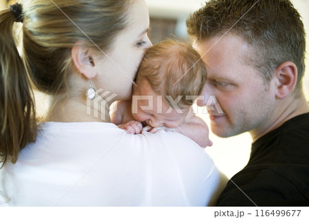 New parents holding newborn baby girl. Unconditional paternal love, idyllic family moment. New parents holding newborn baby girl. Unconditional paternal love, idyllic family moment. 116499677