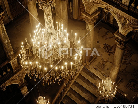luxurious chandelier hangs gracefully from the high ceiling, casting a warm and captivating glow throughout the opulent building. luxurious chandelier hangs gracefully from the high ceiling, casting a warm and captivating glow throughout the opulent building. 116499731