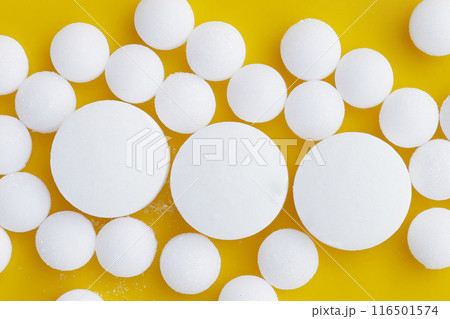 White mothballs on yellow background. White mothballs on yellow background. 116501574