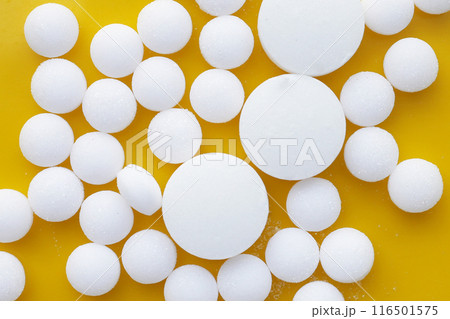 White mothballs on yellow background. White mothballs on yellow background. 116501575