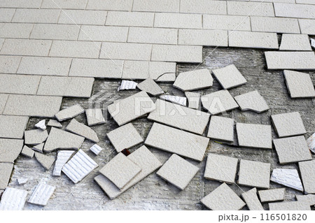 Cracked brown tiles on cement floor 116501820
