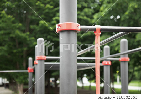 Fitness rubber band for exercise tied on a horizontal bar . Outdoor gym concept . Close up view Fitness rubber band for exercise tied on a horizontal bar . Outdoor gym concept . Close up view 116502563