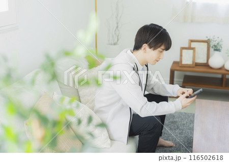 リビングでくつろぐ若い男性 116502618