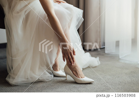 Pretty girl in a long dress adjusting her sandals Pretty girl in a long dress adjusting her sandals 116503908