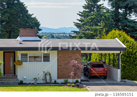 Average family house with mountain view and red car parked under the carport Average family house with mountain view and red car parked under the carport 116505151