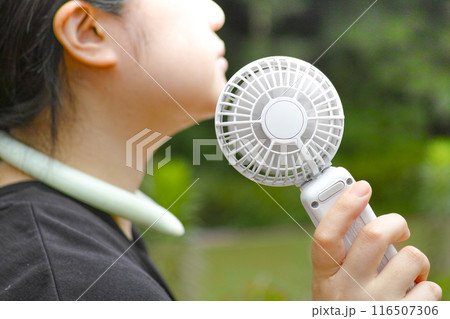 小型扇風機で涼む女性 116507306