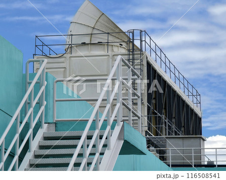 Metal stairs to blue building against sky and clouds 116508541