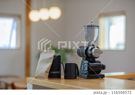 テーブルに置かれたコーヒーミル、ドリップポット、キャニスター缶 116508572