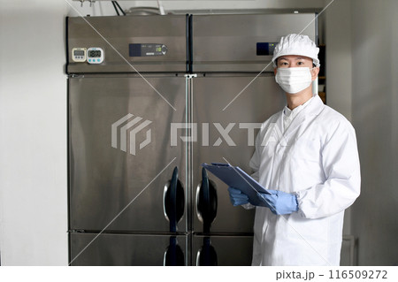 厨房で点検する衛生服を着たアジア人男性 116509272