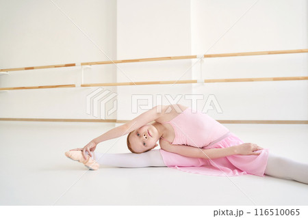 Young ballet girl at studio lesson. Training performance. Stretching exercise 116510065