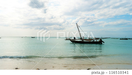 rustic fishing boat sitting in ocean, zanzibar 116510341