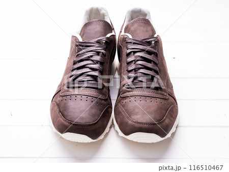 brown leather shoes with laces on wooden background 116510467