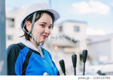 フォークリフトを操縦するヘルメット姿の女性 116510766