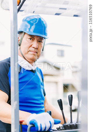 フォークリフトを操縦するヘルメット姿の男性 116510769