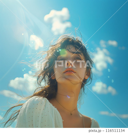 Low-angle portrait of a young woman in white top, with lens flare and a bright blue sky Low-angle portrait of a young woman in white top, with lens flare and a bright blue sky 116511134