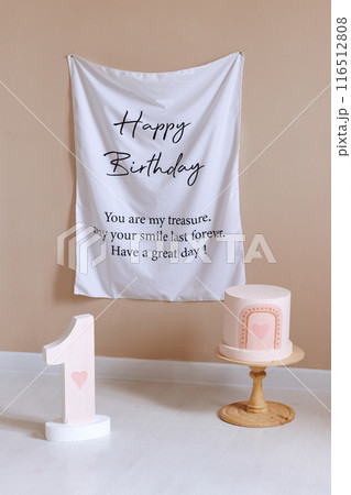 A white banner with the words Happy Birthday written on it hangs on a wall 116512808