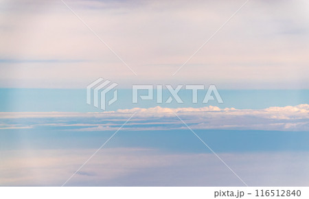 View of airplane wing, blue skies and green land during landing. Airplane window view. 116512840
