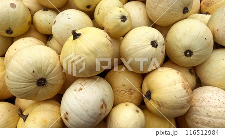Butternut squash piled in a bin, showing their smooth, yellow skin and brown stems Butternut squash piled in a bin, showing their smooth, yellow skin and brown stems 116512984