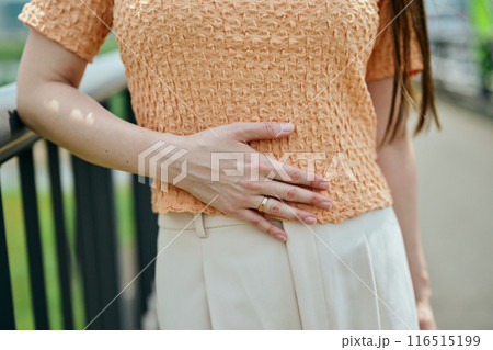 お腹に手を当てる若い女性 お腹に手を当てる若い女性 116515199