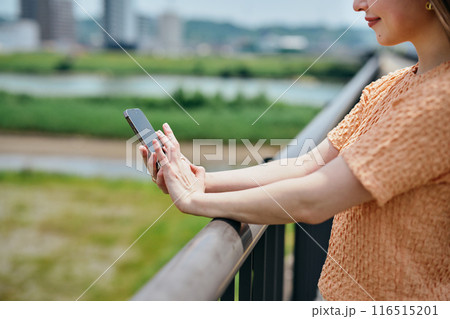スマートフォンを操作する若い女性 116515201