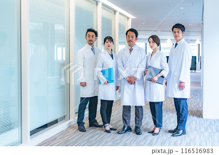 通路に笑顔で並ぶ白衣のグループ 医師 大学医局 病院 科学者 通路に笑顔で並ぶ白衣のグループ 医師 大学医局 病院 科学者 116516983