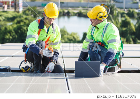 Professional electric engineers survey and inspect solar panels installation on the factory metal sheet roof top, electric engineer team inspecting and check solar cell system. Professional electric engineers survey and inspect solar panels installation on the factory metal sheet roof top, electric engineer team inspecting and check solar cell system. 116517078