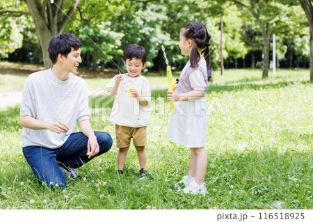 新緑の公園でシャボン玉遊びをする親子 116518925