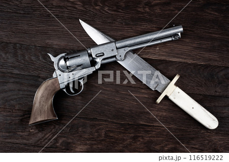 Old West Revolver with bowie knife on wooden deck. 116519222