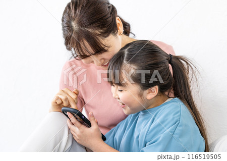 仲良くスマホを見る親娘 仲良くスマホを見る親娘 116519505