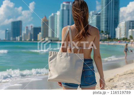 closeup woman holding a blank white tote bag on the beach with a beautiful ocean Generative AI 116519789